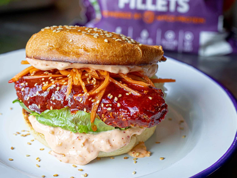 Vegetarian Sweet and Spicy Ramen Burger showing the fillings including grated carrots, lettuce and mayonnaise.