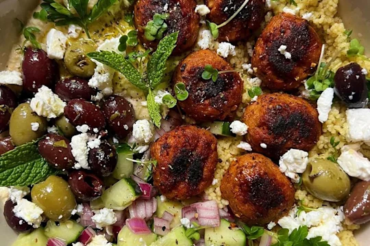 Harissa Swedish Style Balls Salad Bowl displaying Swedish Style Balls, mixed olives, feta, red onions and cucumber.