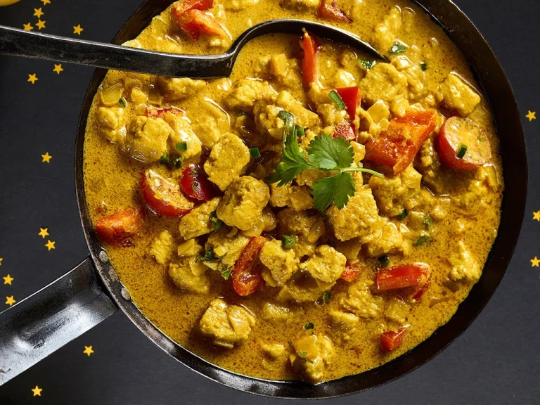 Delicious Quorn pieces in an orange curry sauce fill a saucepan