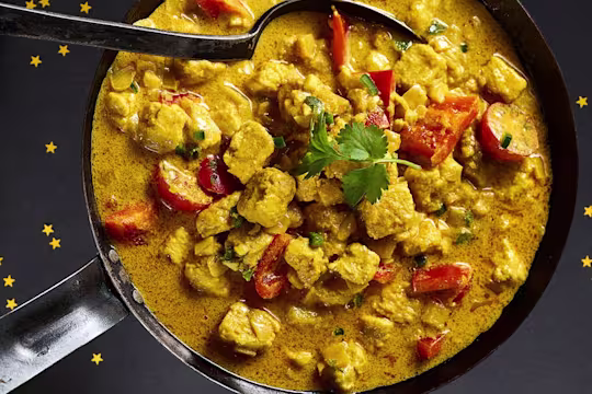 Delicious Quorn pieces in an orange curry sauce fill a saucepan