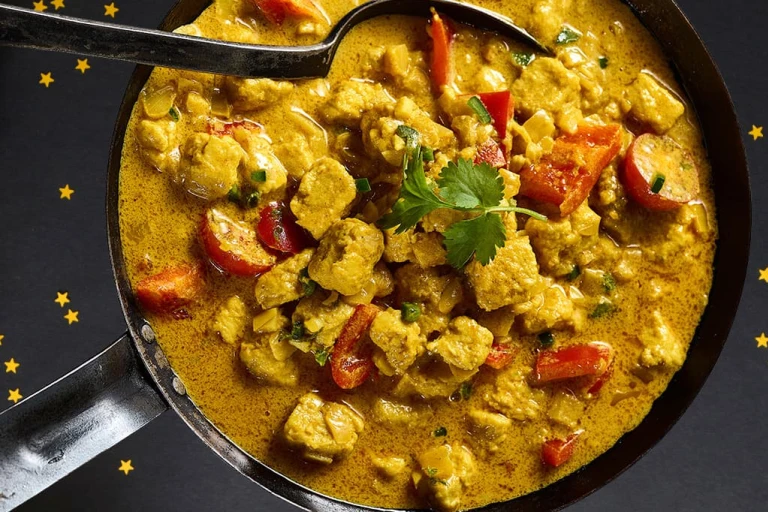 Delicious Quorn pieces in an orange curry sauce fill a saucepan