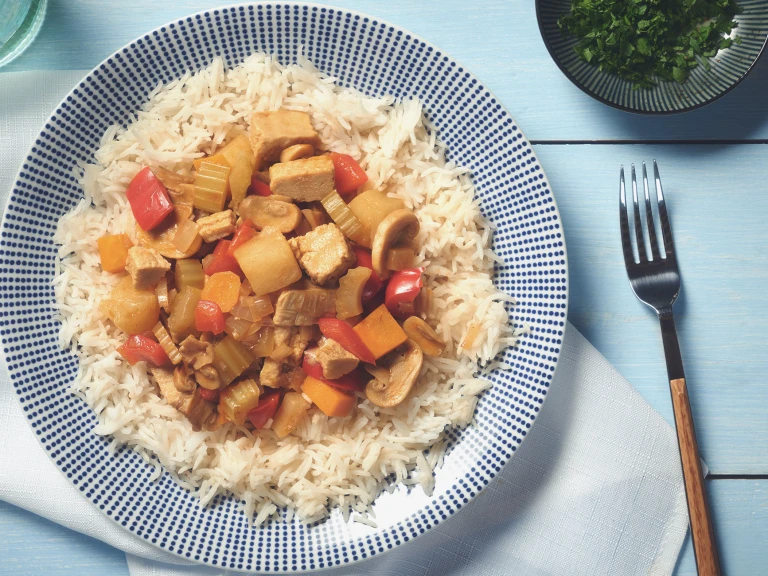 A curry made of Quorn Pieces, mushrooms, peppers, celery, and pineapple atop a bed of white rice.