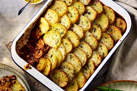 Brilliant Bangers Vegan Hotpot with a slice taken out served in a baking dish.