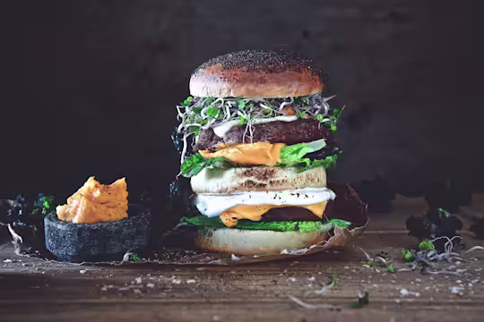 Vegetarian burger made with Quorn Quarter Pounders layered with half a bun, lettuce, cheese, sweet potato mash and beansprouts