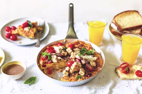 An egg frittata with Quorn Pieces, tomatoes, and mozzarella with a balsaminc cream dressing on the side.