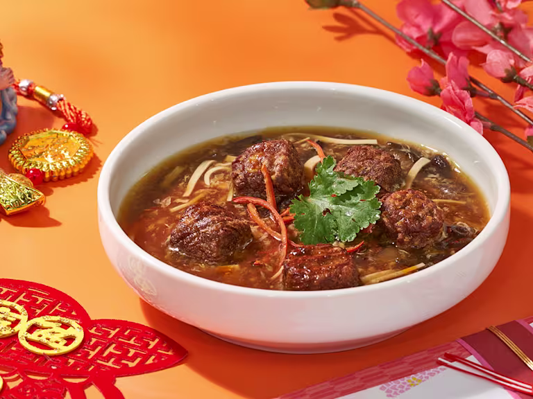 Quorn swedish style meatballs in a bowl of soup with herbs and spices.