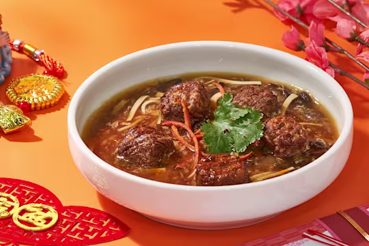 Quorn swedish style meatballs in a bowl of soup with herbs and spices.