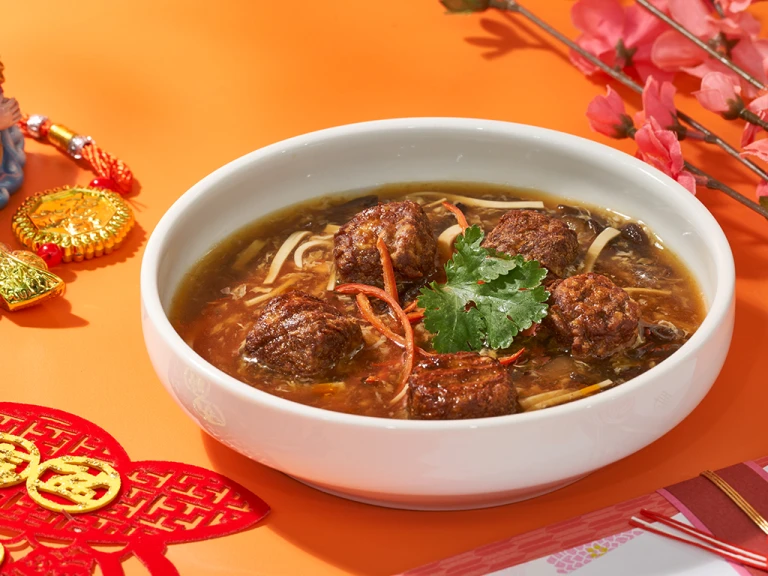 Quorn swedish style meatballs in a bowl of soup with herbs and spices. 