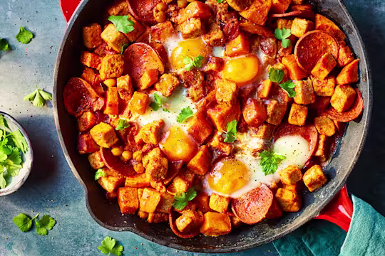 Vegetarian Hash with Quorn Pieces and Pepperoni served in a frying pan with mint leaves.