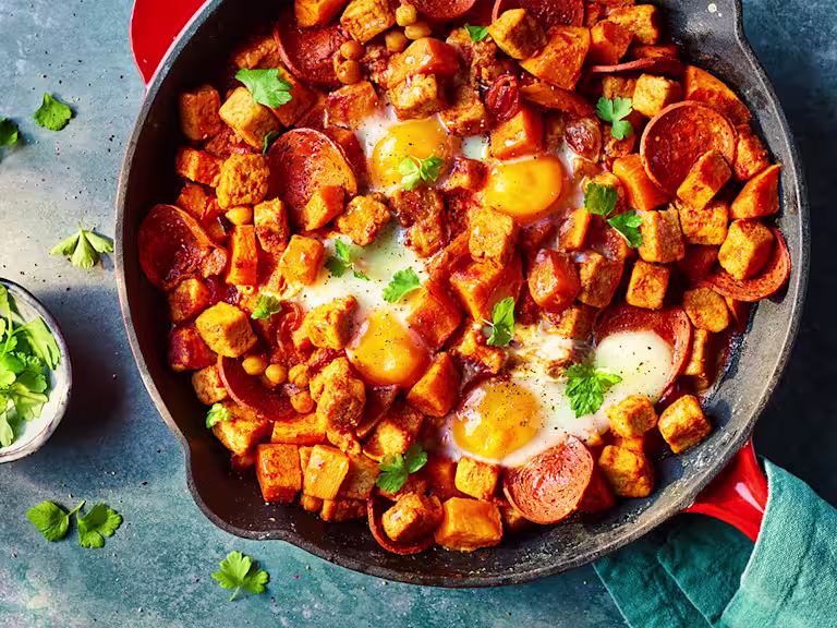 Vegetarian Hash with Quorn Pieces and Pepperoni served in a frying pan with mint leaves.