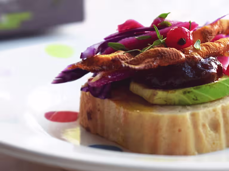 Vegetarian Christmas Canapes, made with Quorn Roast, brussel sprouts, cabbage, carrot and red currants, served on a plate.