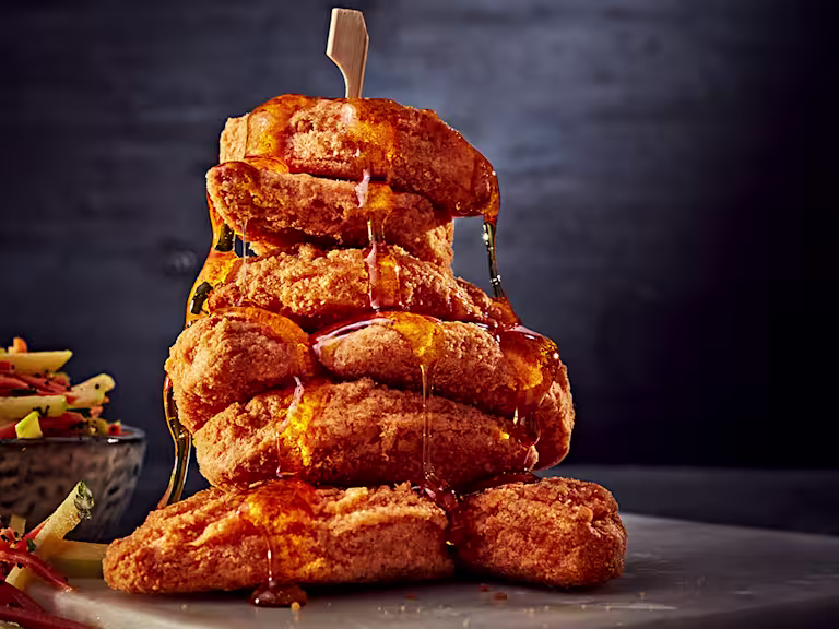 A stack of Quorn Southern Fried Chicken Bites drizzled with maple syrup