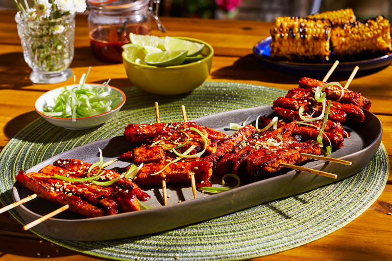A platter with four servings of Korean BBQ Skewers made with Quorn Vegan Fillets topped with sesame and scallions.