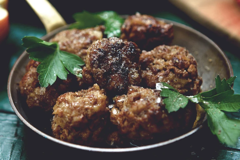 A dish of seven meatballs made with Quorn Mince and garnished with parsley.