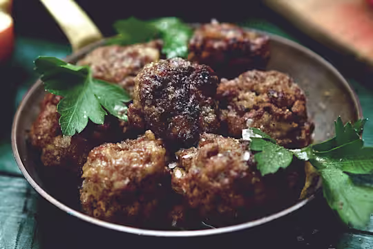 Golden-brown vegetarian meatballs made with Quorn Mince, served in a rustic pan with fresh parsley garnish