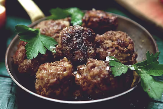 Golden-brown vegetarian meatballs made with Quorn Mince, served in a rustic pan with fresh parsley garnish