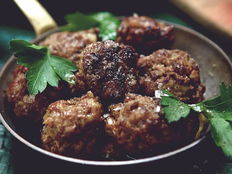 Golden-brown vegetarian meatballs made with Quorn Mince, served in a rustic pan with fresh parsley garnish
