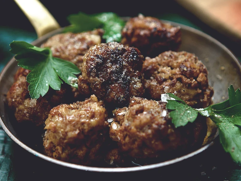 A dish of seven meatballs made with Quorn Mince and garnished with parsley.