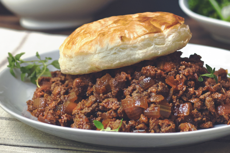 Vegetarian pie made with Quorn Mince and onions served on a plate topped with a pastry lid and sprigs of thyme
