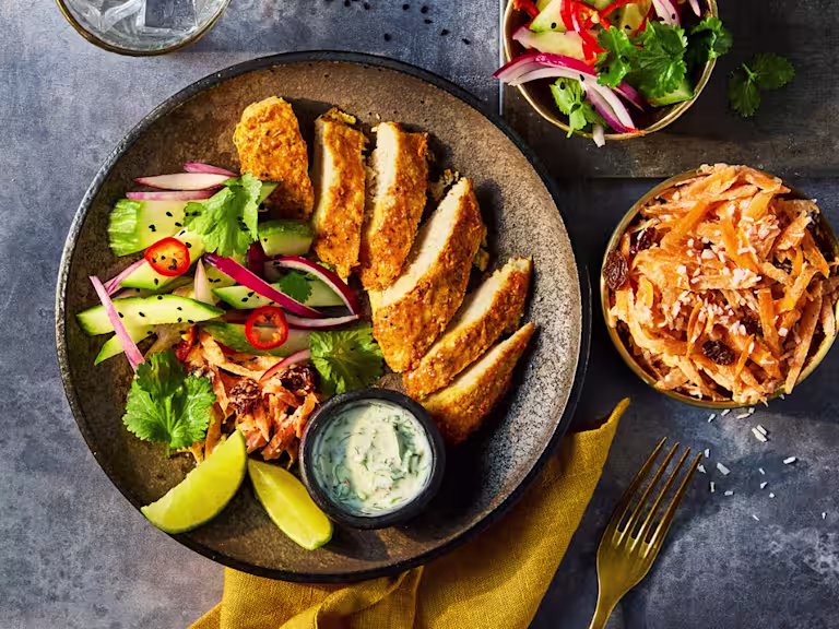 Quorn Chicken Fillets with a tandoori coating with a side salad and mint yoghurt dip served in a grey dish.