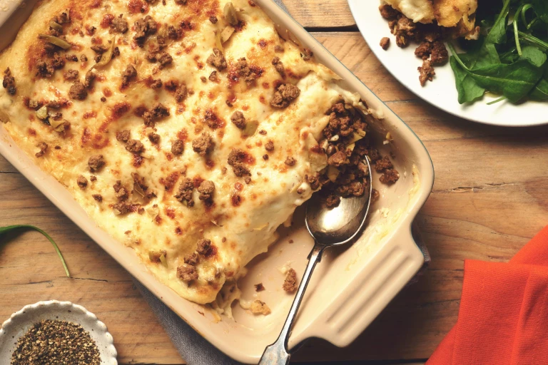 Vegetarian Cannelloni made with meat free Quorn Mince topped with béchamel sauce and scattered mince in a dish