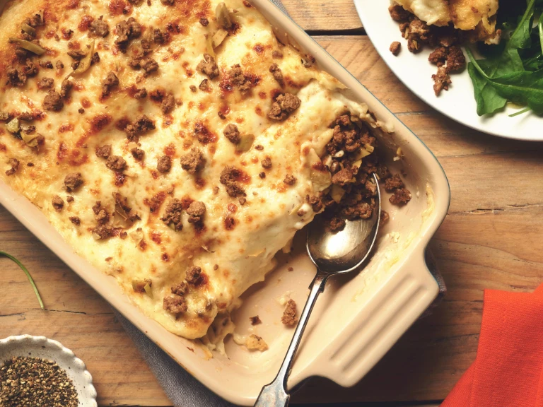 Vegetarian Cannelloni made with meat free Quorn Mince topped with béchamel sauce and scattered mince in a dish
