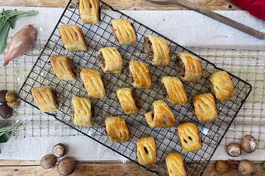 Vegan sausage rolls served on a cooling rack with mushrooms on the side