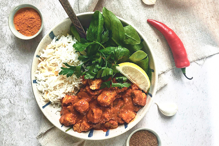 Quorn Vegan Masala Curry, made with Quorn Vegan Pieces, onion, turmeric, paprika, chilli, served with rice, lettuce and lemon in a bowl.