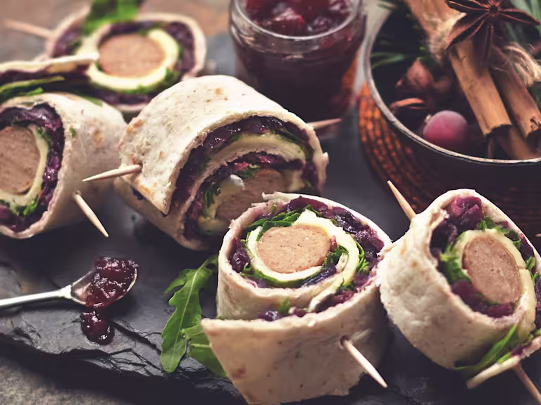Several Quorn Vegetarian Sausage Wraps with the Quorn Vegetarian Sausage visibile served with cranberry jam.
