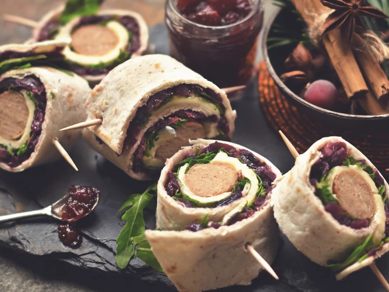 Several Quorn Vegetarian Sausage Wraps with the Quorn Vegetarian Sausage visibile served with cranberry jam. 