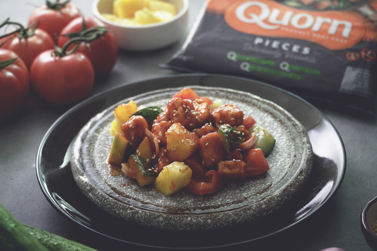 Sweet and sour Quorn Pieces with pineapple and peppers, dressed with sesame seeds on a plate dressed with sesame seeds