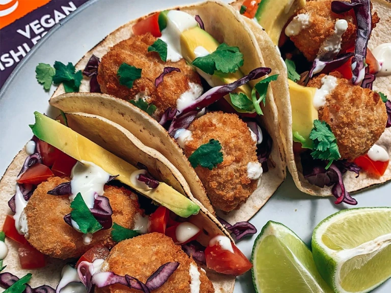 Three tacos filled with Quorn Vegan Fishless Scampi made in an air fryer, avocado, red cabbage, and a yoghurt dressing.