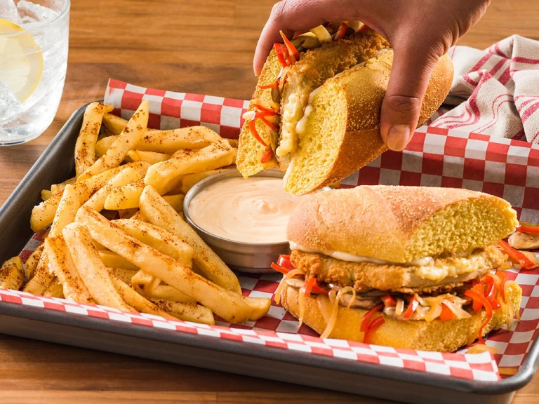 Meat-free Hoagie on tray with chips and dipping sauce