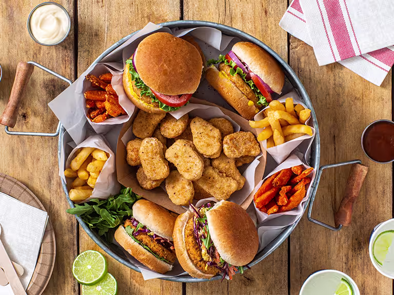 Four pittas stuffed with Quorn Crispy Nuggets, tomato sauce, yogurt sauce, tomato salad, and lettuce.