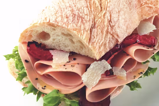 Sandwich made with Quorn Vegetarian Ham Slices on top of lettuce, dressed with parmesan and sundried tomato served in ciabatta