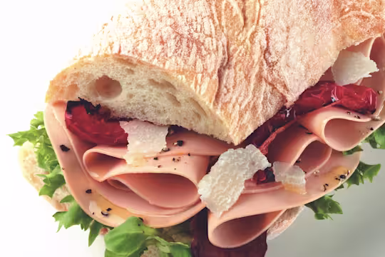 Sandwich made with Quorn Vegetarian Ham Slices on top of lettuce, dressed with parmesan and sundried tomato served in ciabatta