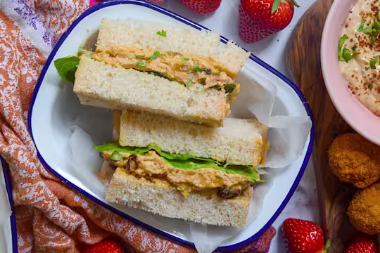 Vegetarian sandwich sliced in half facing upwards served in a white dish.