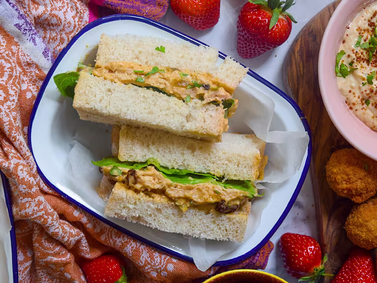 Vegetarian sandwich sliced in half facing upwards served in a white dish.