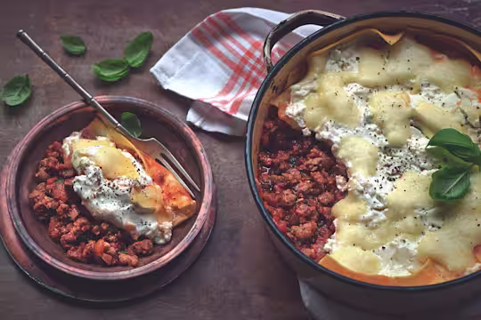 Quick and easy meal of lasagne made with Quorn Mince served in a saucepan and a side serving in a small bowl
