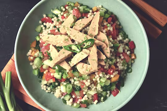 A bowl of giant couscous zingy chili and lime salad with Quorn Roast Mini Fillets.