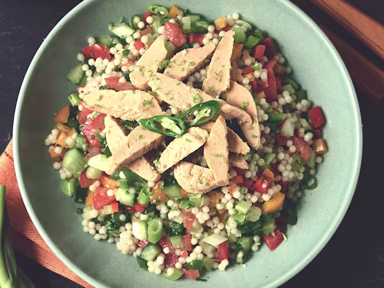 A bowl of giant couscous zingy chili and lime salad with Quorn Roast Mini Fillets.