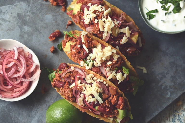 Vegetarian chipotle tacos made with Quorn mince accompanied with pickled onion and sour cream