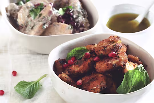 Vegetarian Moroccan recipe made with Quorn Crispy Nuggets served in a bowl garnished with pomegranate and green leaves