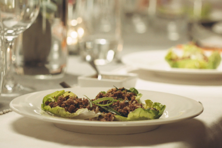 Two lettuce cups filled with a Quorn Mince laab salad on a white plate.