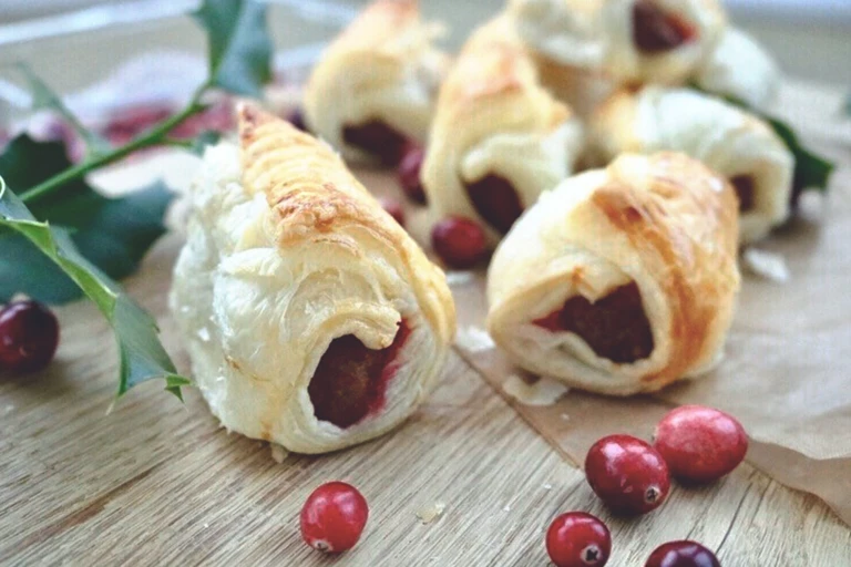 Quorn Vegetarian Cocktail Sausages with cranberry and served with cranberries on a chopping board