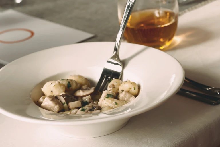 Healthy dinner recipe of Quorn Pieces and mushroom gnocchi served in a deep bowl with a fork in the middle