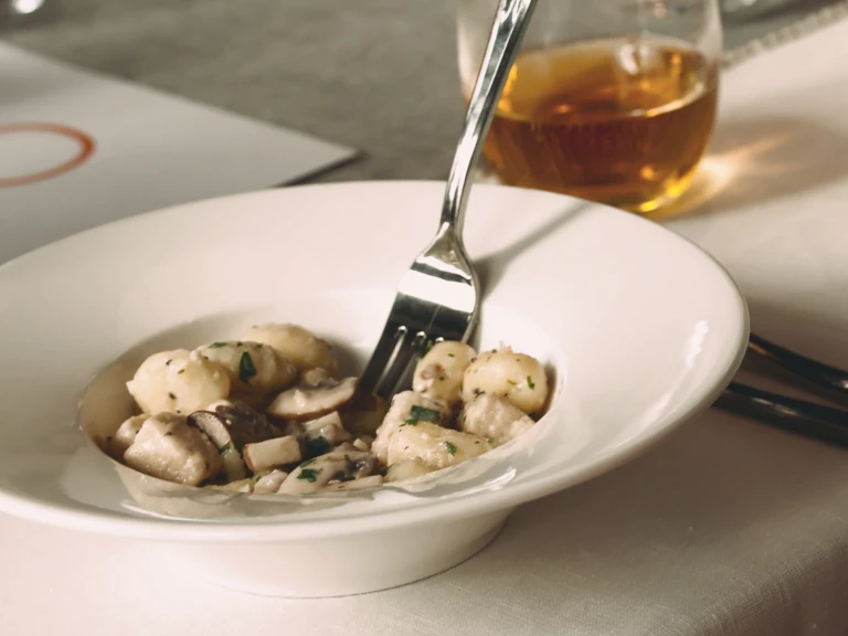 Healthy dinner recipe of Quorn Pieces and mushroom gnocchi served in a deep bowl with a fork in the middle