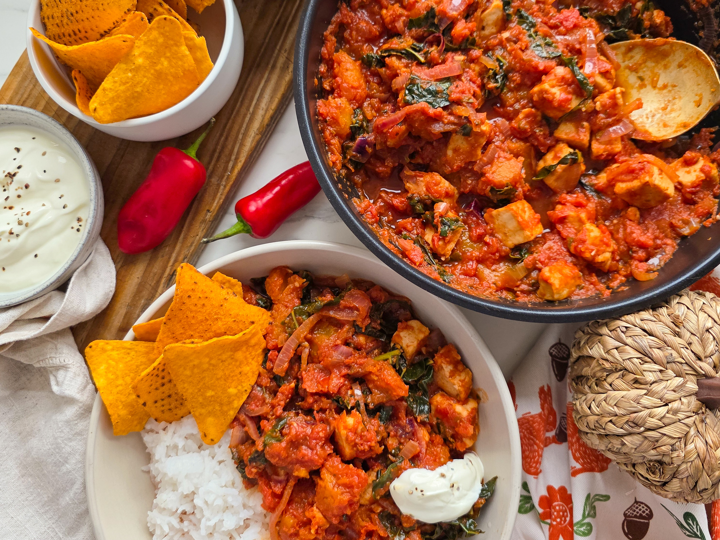 Vegetarian Chicken Chilli in a white bowl with rice and Tortilla chips.