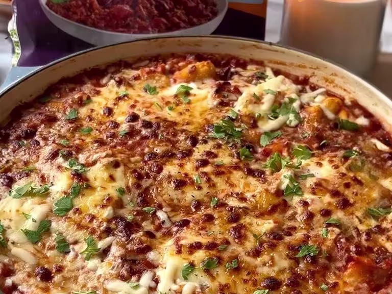 Vegetarian gnocchi lasagne with melted and browned cheese in a grey dish.