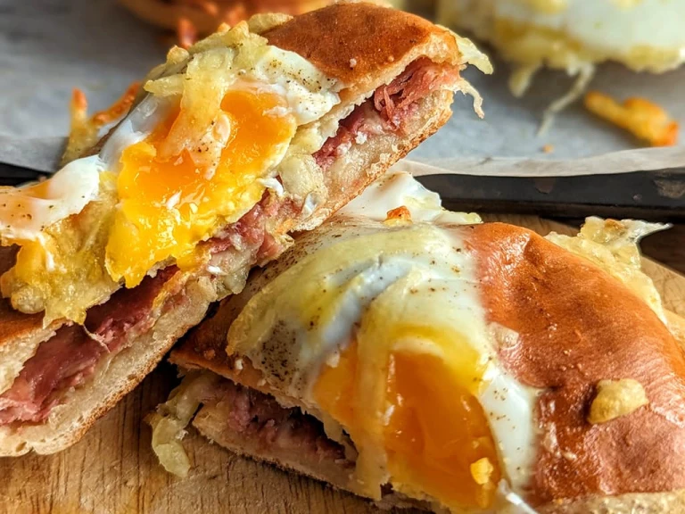 Bagel sliced in half filled with a runny egg, Quorn Finely Sliced Ham Style Slices and topped with melted cheese.